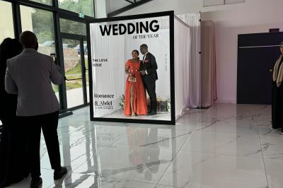 Un groupe de personnes en tenue traditionnelle célèbre un événement sous des lustres dans une grande salle éclairée.