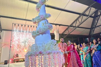 Un groupe de personnes en tenue traditionnelle célèbre un événement sous des lustres dans une grande salle éclairée.