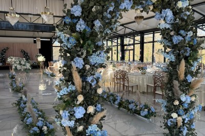 Un groupe de personnes en tenue traditionnelle célèbre un événement sous des lustres dans une grande salle éclairée.