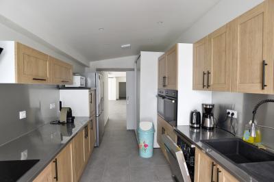 Projecteurs LED rouges fixés sur une barre métallique, éclairant un mur avec des reflets lumineux violets.