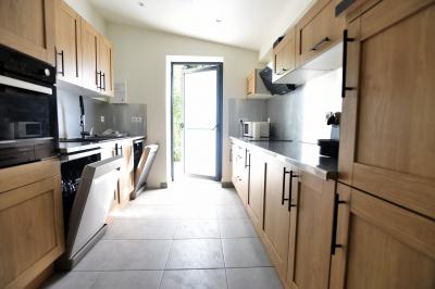 Projecteurs LED rouges fixés sur une barre métallique, éclairant un mur avec des reflets lumineux violets.