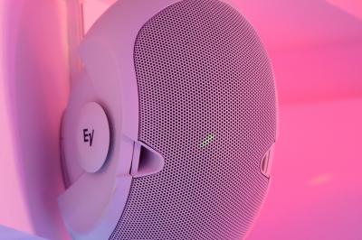 Projecteurs LED rouges fixés sur une barre métallique, éclairant un mur avec des reflets lumineux violets.