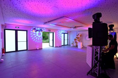 Projecteurs LED rouges fixés sur une barre métallique, éclairant un mur avec des reflets lumineux violets.