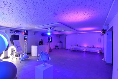 Projecteurs LED rouges fixés sur une barre métallique, éclairant un mur avec des reflets lumineux violets.