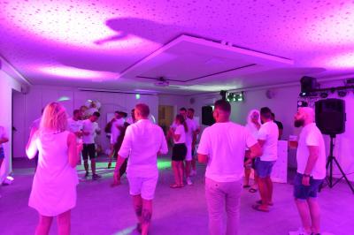 Projecteurs LED rouges fixés sur une barre métallique, éclairant un mur avec des reflets lumineux violets.