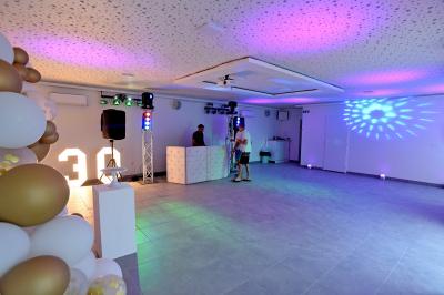 Projecteurs LED rouges fixés sur une barre métallique, éclairant un mur avec des reflets lumineux violets.