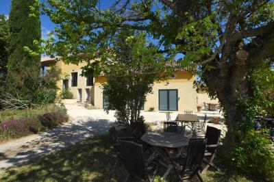 Salle de bain moderne avec carrelage gris, meuble suspendu, miroir, petite fenêtre et poubelle blanche au sol.