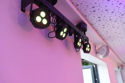 Salle de bain moderne avec carrelage gris, meuble suspendu, miroir, petite fenêtre et poubelle blanche au sol.