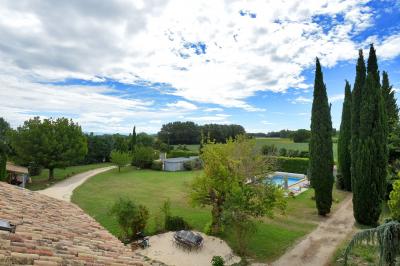 Salle de bain moderne avec carrelage gris, meuble suspendu, miroir, petite fenêtre et poubelle blanche au sol.