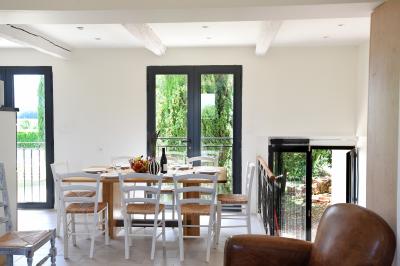 Salle de bain moderne avec carrelage gris, meuble suspendu, miroir, petite fenêtre et poubelle blanche au sol.