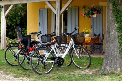 Salle de bain moderne avec carrelage gris, meuble suspendu, miroir, petite fenêtre et poubelle blanche au sol.