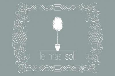 Salle de bain moderne avec carrelage gris, meuble suspendu, miroir, petite fenêtre et poubelle blanche au sol.