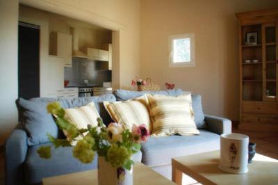 Salle de bain moderne avec carrelage gris, meuble suspendu, miroir, petite fenêtre et poubelle blanche au sol.