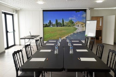 Salle de bain moderne avec carrelage gris, meuble suspendu, miroir, petite fenêtre et poubelle blanche au sol.