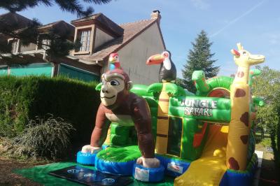 Des personnes assises en extérieur assistent à une cérémonie devant des tables décorées, près de chalets en bois.