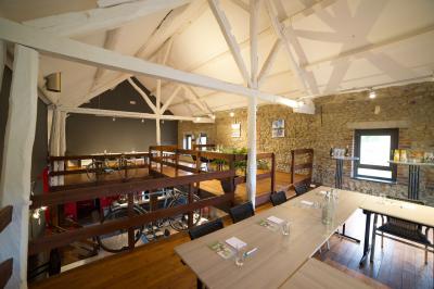 Groupe de personnes rassemblées devant une maison en pierre avec un chapiteau, sur une pelouse par temps ensoleillé.