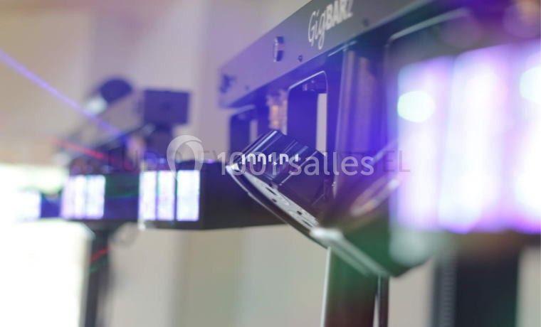 Projecteurs lumineux alignés, émettant des faisceaux colorés dans un environnement intérieur flou.