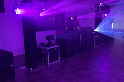 Installation de matériel de sonorisation et d'éclairage avec projecteurs et enceintes dans une salle de réception.