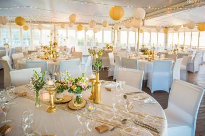 Buffet lumineux avec compartiments remplis de salades et condiments, entouré de bols dans une salle de restaurant.