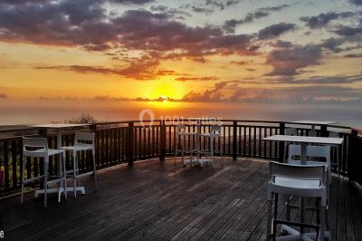 Salle de conférence vide avec des rangées de chaises blanches et un plafond en bois.
