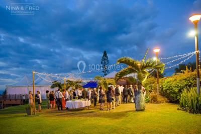 Salle de conférence vide avec des rangées de chaises blanches et un plafond en bois.
