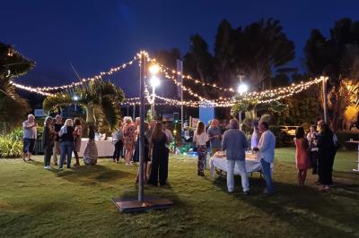 Salle de conférence vide avec des rangées de chaises blanches et un plafond en bois.