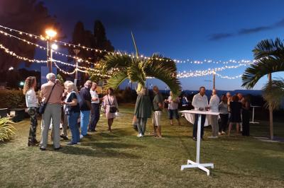 Salle de conférence vide avec des rangées de chaises blanches et un plafond en bois.