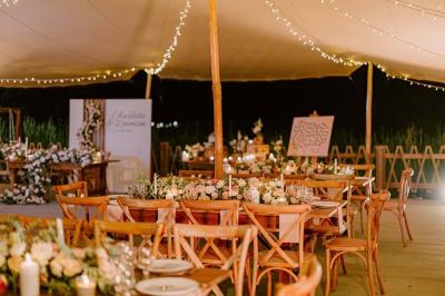 Groupe de personnes rassemblées dans un jardin éclairé par des guirlandes lumineuses lors d'un événement nocturne.