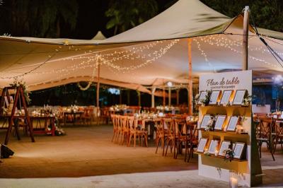 Groupe de personnes rassemblées dans un jardin éclairé par des guirlandes lumineuses lors d'un événement nocturne.
