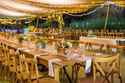 Groupe de personnes rassemblées dans un jardin éclairé par des guirlandes lumineuses lors d'un événement nocturne.