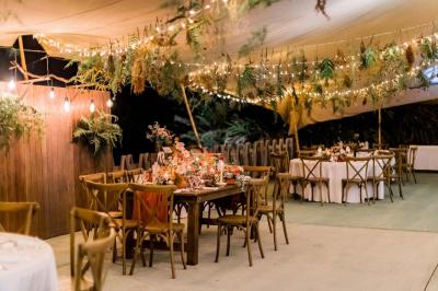 Groupe de personnes rassemblées dans un jardin éclairé par des guirlandes lumineuses lors d'un événement nocturne.