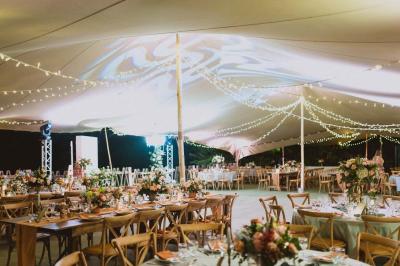 Groupe de personnes rassemblées dans un jardin éclairé par des guirlandes lumineuses lors d'un événement nocturne.
