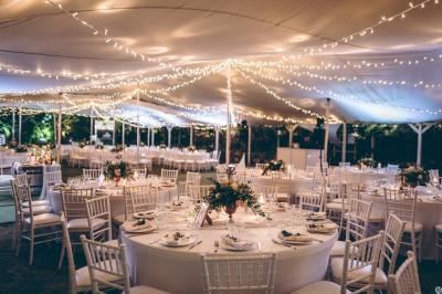 Bancs en bois disposés sur une pelouse pour une cérémonie en plein air, entourés de végétation et de fleurs.