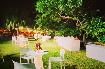 Bancs en bois disposés sur une pelouse pour une cérémonie en plein air, entourés de végétation et de fleurs.