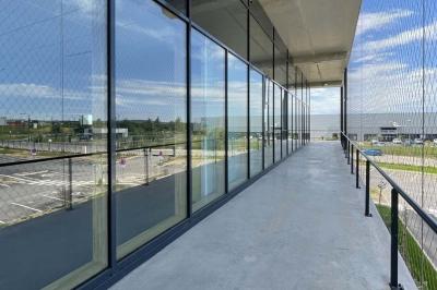 Comptoir moderne devant un mur végétal intérieur avec arches, éclairage discret et équipements de restauration.