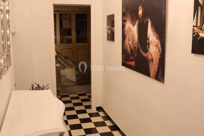 Chambre avec un lit double, éclairage doux et une grande bibliothèque en bois remplie de livres en arrière-plan.