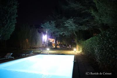 Chambre avec un lit double, éclairage doux et une grande bibliothèque en bois remplie de livres en arrière-plan.