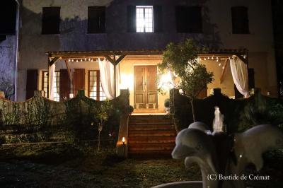 Chambre avec un lit double, éclairage doux et une grande bibliothèque en bois remplie de livres en arrière-plan.