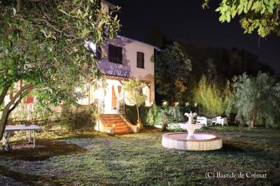 Chambre avec un lit double, éclairage doux et une grande bibliothèque en bois remplie de livres en arrière-plan.
