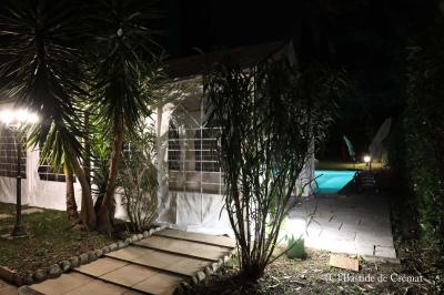 Chambre avec un lit double, éclairage doux et une grande bibliothèque en bois remplie de livres en arrière-plan.