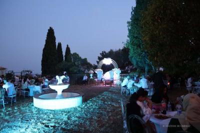 Chambre avec un lit double, éclairage doux et une grande bibliothèque en bois remplie de livres en arrière-plan.