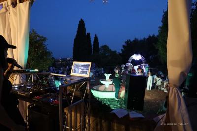 Chambre avec un lit double, éclairage doux et une grande bibliothèque en bois remplie de livres en arrière-plan.
