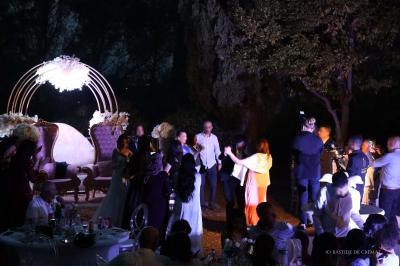 Chambre avec un lit double, éclairage doux et une grande bibliothèque en bois remplie de livres en arrière-plan.