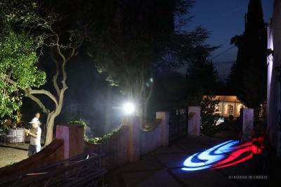 Chambre avec un lit double, éclairage doux et une grande bibliothèque en bois remplie de livres en arrière-plan.