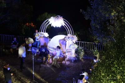 Chambre avec un lit double, éclairage doux et une grande bibliothèque en bois remplie de livres en arrière-plan.