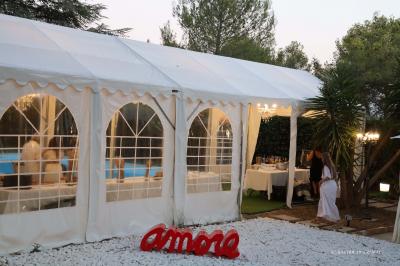 Chambre avec un lit double, éclairage doux et une grande bibliothèque en bois remplie de livres en arrière-plan.