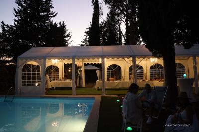 Chambre avec un lit double, éclairage doux et une grande bibliothèque en bois remplie de livres en arrière-plan.