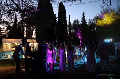 Chambre avec un lit double, éclairage doux et une grande bibliothèque en bois remplie de livres en arrière-plan.