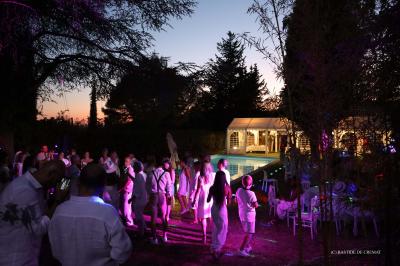 Chambre avec un lit double, éclairage doux et une grande bibliothèque en bois remplie de livres en arrière-plan.