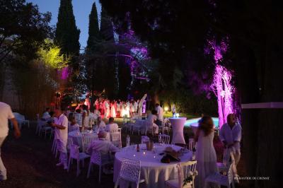 Chambre avec un lit double, éclairage doux et une grande bibliothèque en bois remplie de livres en arrière-plan.